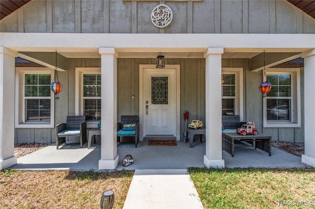 property entrance featuring covered porch and board and batten siding