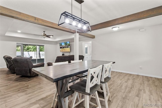 dining area with a ceiling fan, baseboards, beam ceiling, and light wood-type flooring