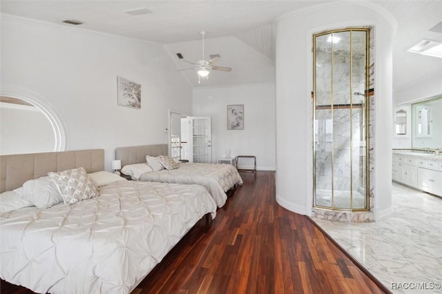 bedroom featuring visible vents, a sink, wood finished floors, baseboards, and vaulted ceiling