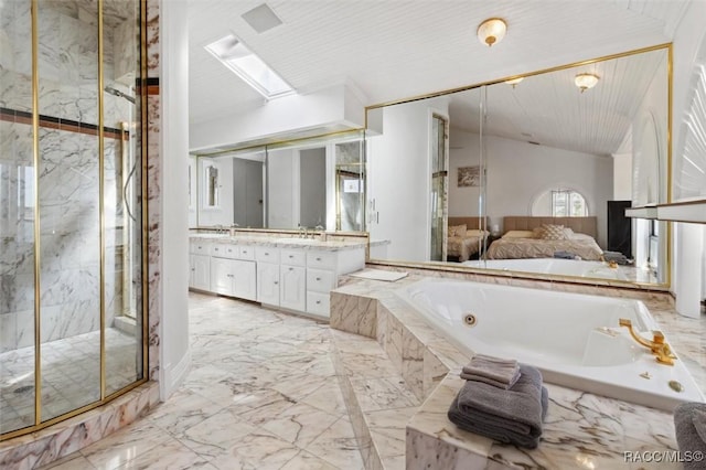 bathroom featuring vanity, a marble finish shower, vaulted ceiling with skylight, a garden tub, and marble finish floor