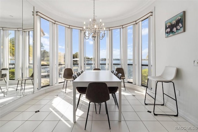 dining space with crown molding, baseboards, a water view, light tile patterned flooring, and a notable chandelier