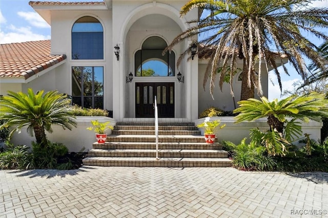 entrance to property featuring french doors and stucco siding