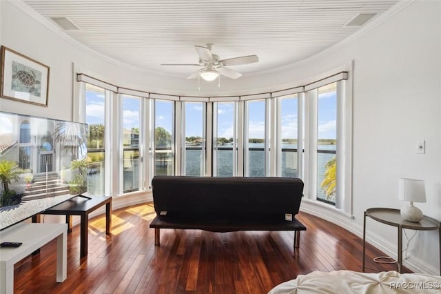 sunroom / solarium featuring a water view and ceiling fan