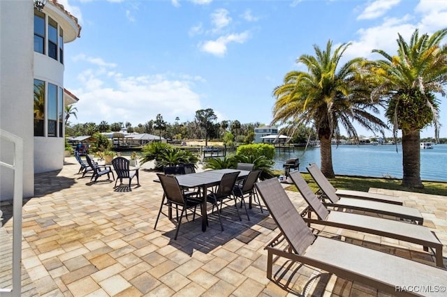 view of patio with outdoor dining area and a water view