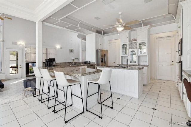 kitchen with a sink, a peninsula, appliances with stainless steel finishes, and a breakfast bar