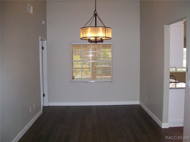 unfurnished dining area with dark wood-type flooring