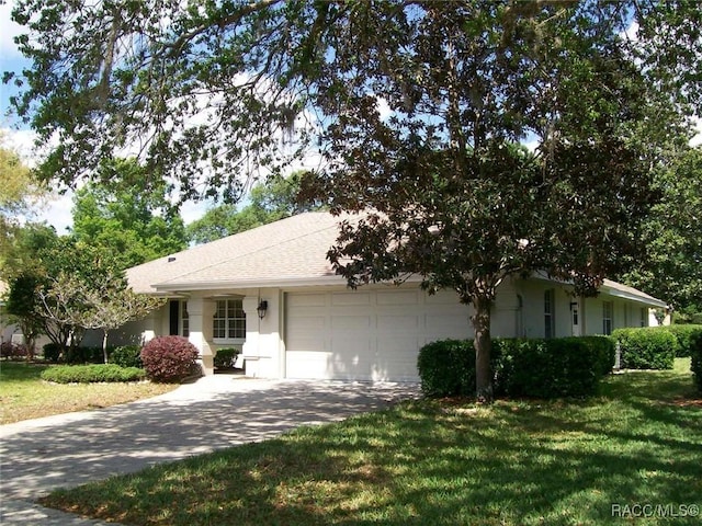 ranch-style home featuring a garage and a front lawn