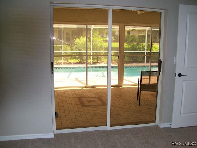 doorway to outside featuring carpet flooring