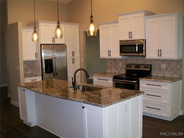 kitchen featuring white cabinetry, stainless steel appliances, an island with sink, and pendant lighting