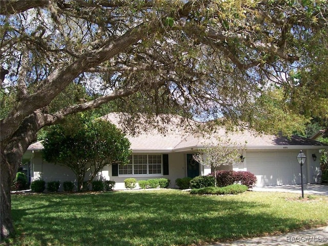 ranch-style house featuring a garage and a front yard