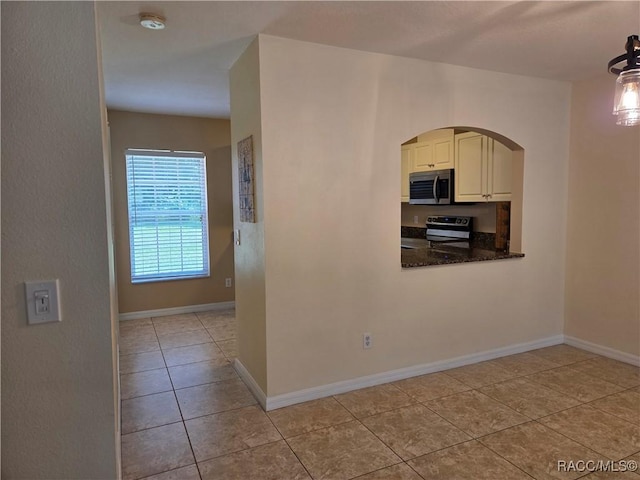 933 N Rembrandt Way, Inverness, FL 34453 - kitchen featuring stainless steel appliances, light tile patterned floors, arched walkways, and pendant lighting