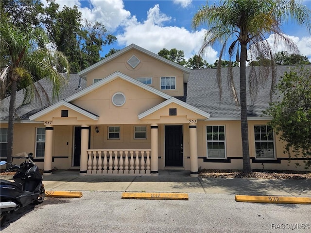 933 N Rembrandt Way, Inverness, FL 34453 - view of front of house with uncovered parking, roof with shingles, a porch, and stucco siding