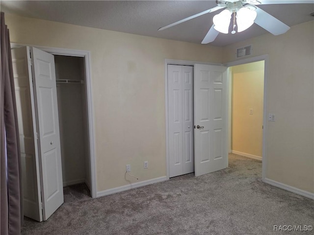 933 N Rembrandt Way, Inverness, FL 34453 - unfurnished bedroom featuring multiple closets, carpet, and ceiling fan