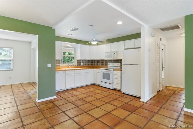 kitchen with white cabinets, decorative backsplash, white appliances, and a healthy amount of sunlight