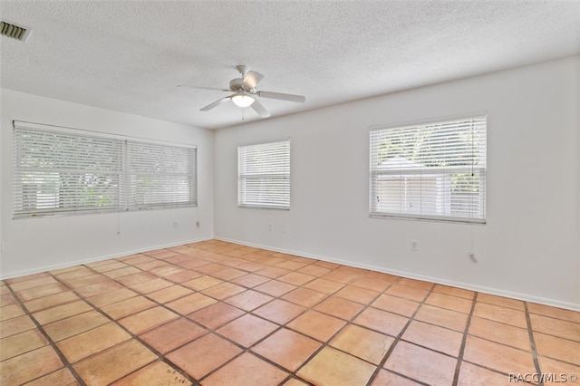 tiled spare room featuring ceiling fan and a textured ceiling