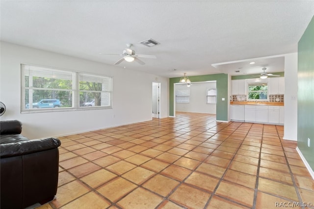 tiled living room with plenty of natural light and a textured ceiling