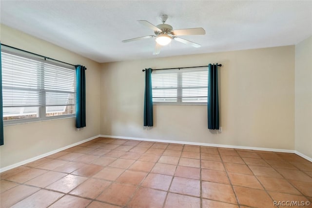 unfurnished room featuring ceiling fan, a healthy amount of sunlight, and light tile patterned floors