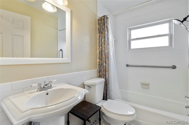 full bathroom with sink, shower / bath combination with curtain, tile walls, and toilet