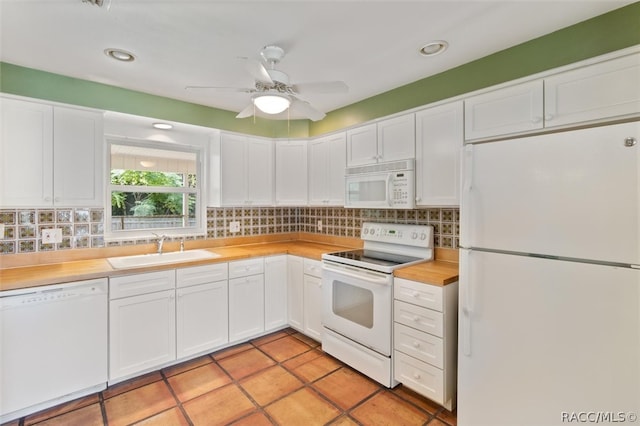 kitchen featuring decorative backsplash, white cabinetry, sink, and white appliances