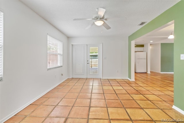 tiled spare room featuring ceiling fan and a textured ceiling