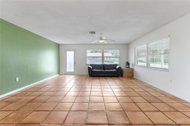 unfurnished living room with light tile patterned floors, a textured ceiling, and ceiling fan