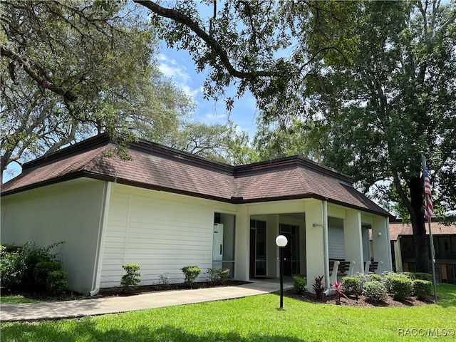 rear view of house featuring a lawn