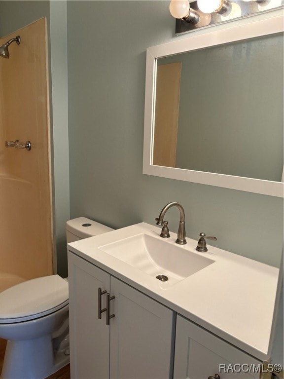 bathroom featuring vanity, toilet, and walk in shower