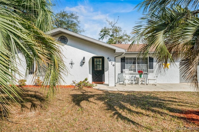 view of front of house with a patio area and a front lawn