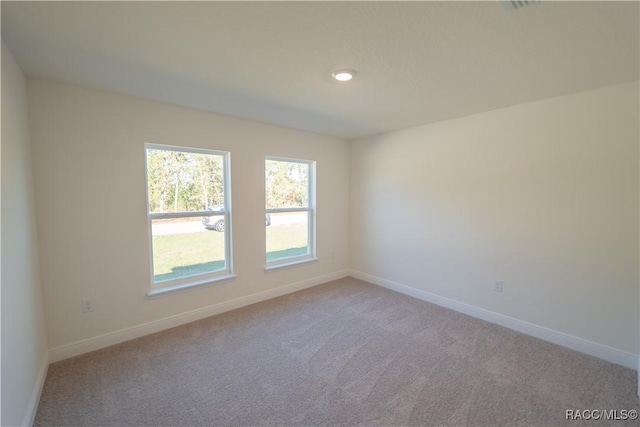 unfurnished room with light carpet