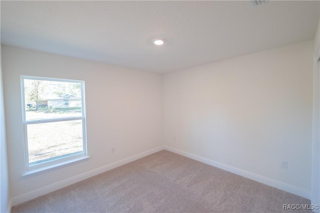 carpeted spare room featuring a wealth of natural light