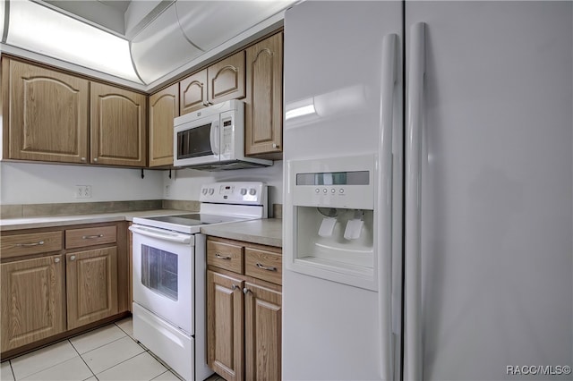 kitchen featuring white appliances and light tile patterned flooring