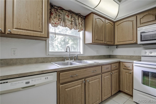 kitchen featuring sink, light tile patterned floors, and white appliances