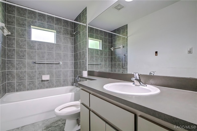 full bathroom with tile patterned flooring, vanity, toilet, and tiled shower / bath