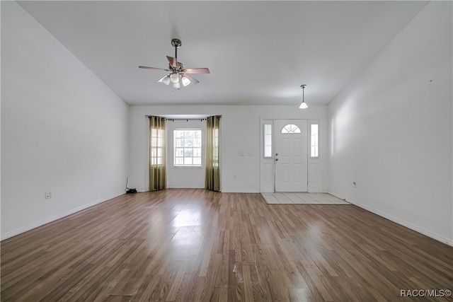 foyer entrance featuring hardwood / wood-style floors, vaulted ceiling, and ceiling fan