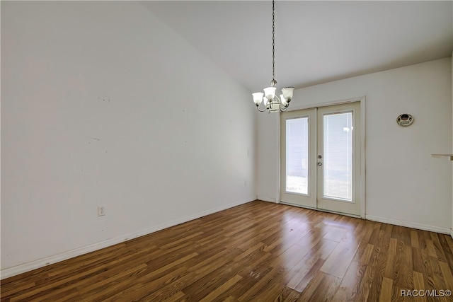 empty room with vaulted ceiling, french doors, a chandelier, and dark hardwood / wood-style floors