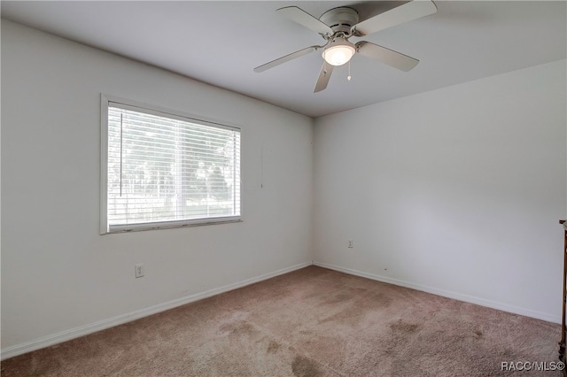 empty room with ceiling fan and light carpet