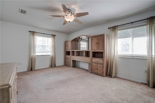 unfurnished office featuring ceiling fan and light colored carpet