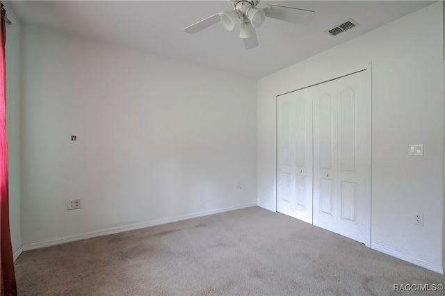 unfurnished bedroom featuring carpet, ceiling fan, and a closet