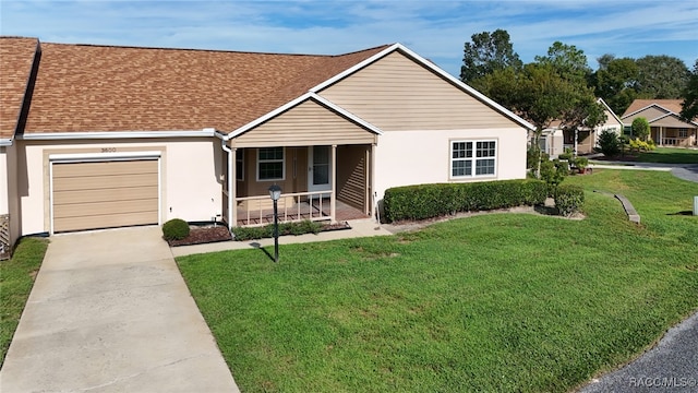 single story home featuring covered porch, a front yard, and a garage