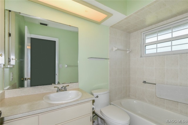 full bathroom featuring vanity, toilet, and tiled shower / bath