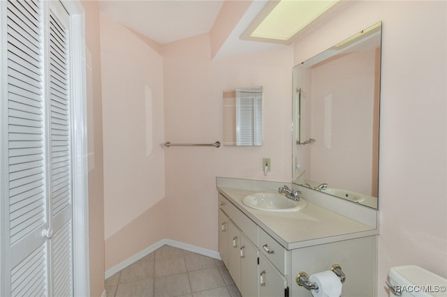 bathroom with tile patterned flooring, vanity, and toilet