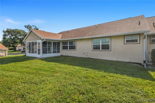 back of property with a sunroom and a yard