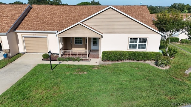 ranch-style house featuring a garage, covered porch, and a front yard