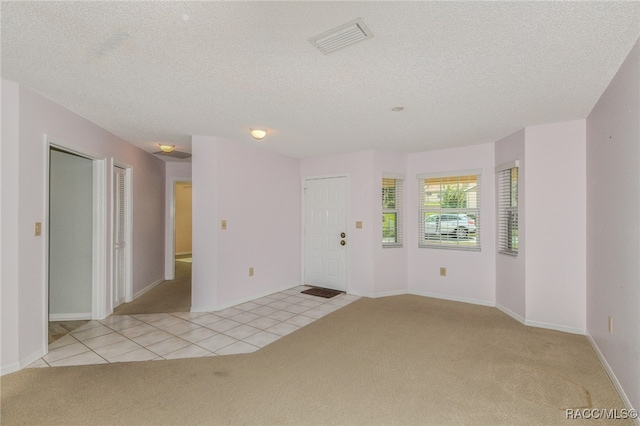 empty room featuring light tile patterned floors and a textured ceiling