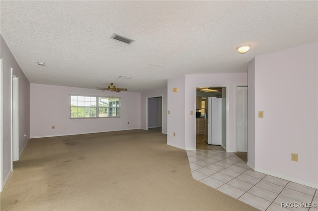 carpeted spare room with ceiling fan and a textured ceiling