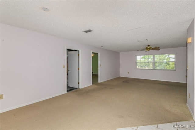 empty room with a textured ceiling, ceiling fan, and light carpet