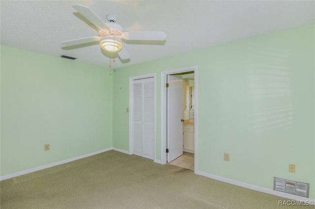 carpeted spare room featuring ceiling fan and a textured ceiling