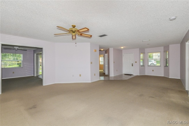 unfurnished living room with carpet and a textured ceiling