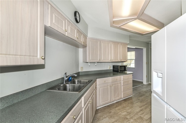 kitchen featuring light brown cabinetry, hardwood / wood-style flooring, and sink