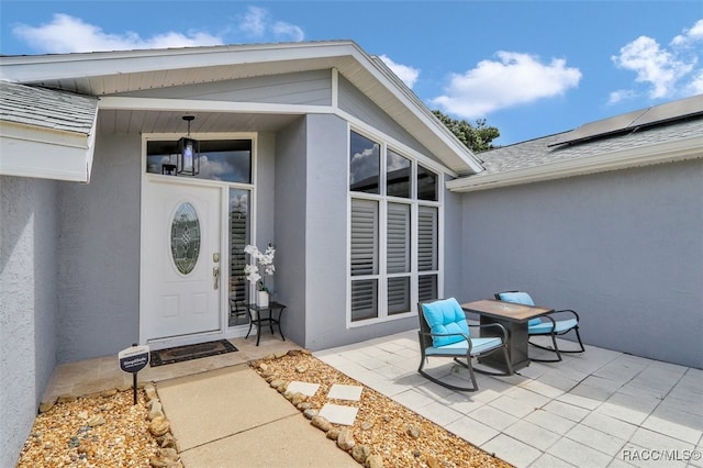 391 E Falconry Ct, Hernando, FL 34442 - doorway to property with stucco siding and roof with shingles